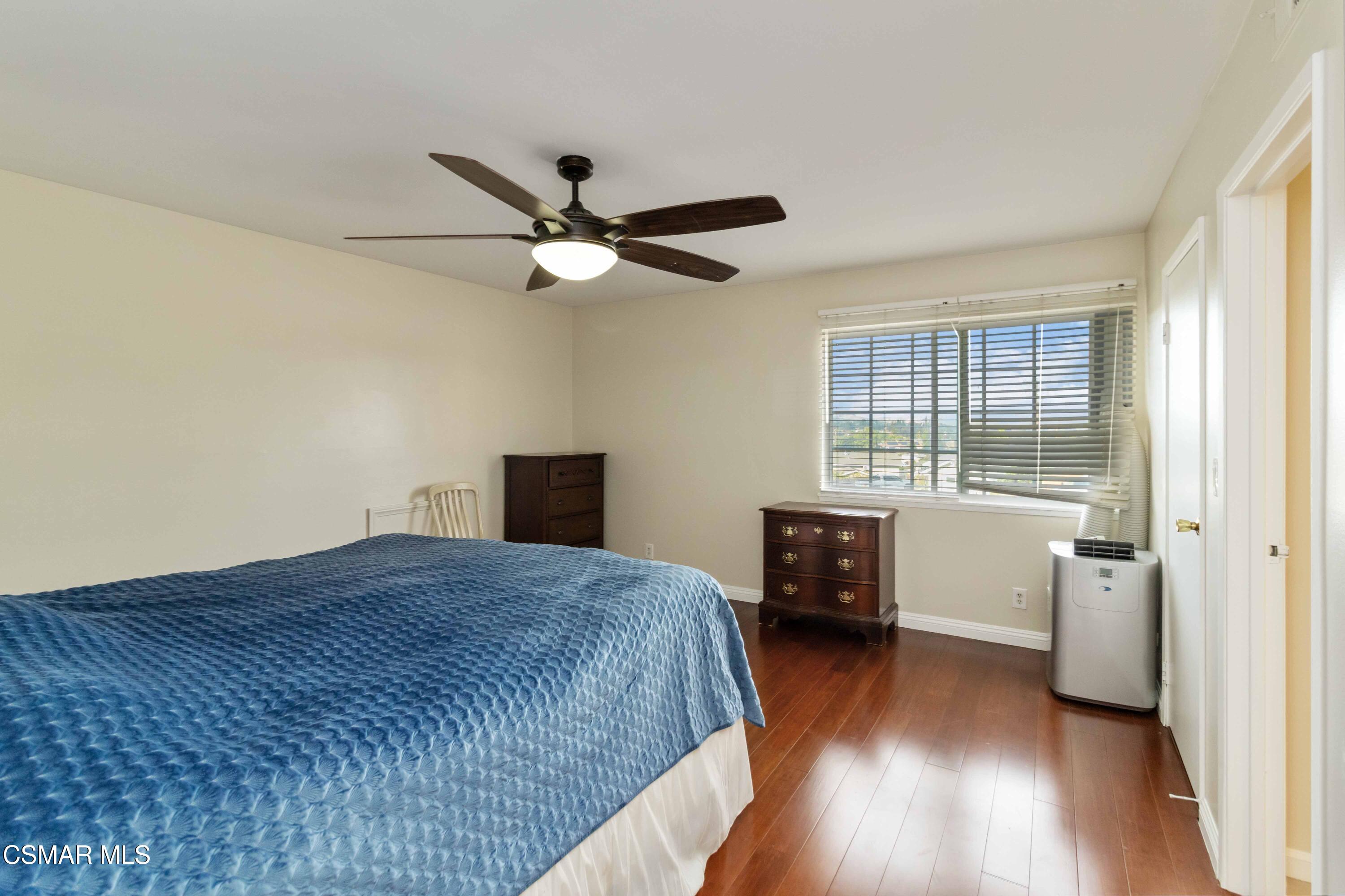 705 Wishard Avenue Simi Valley, CA 93065 - Photo 22 of 50 a spacious bedroom with a bed and a table in it with wooden floor