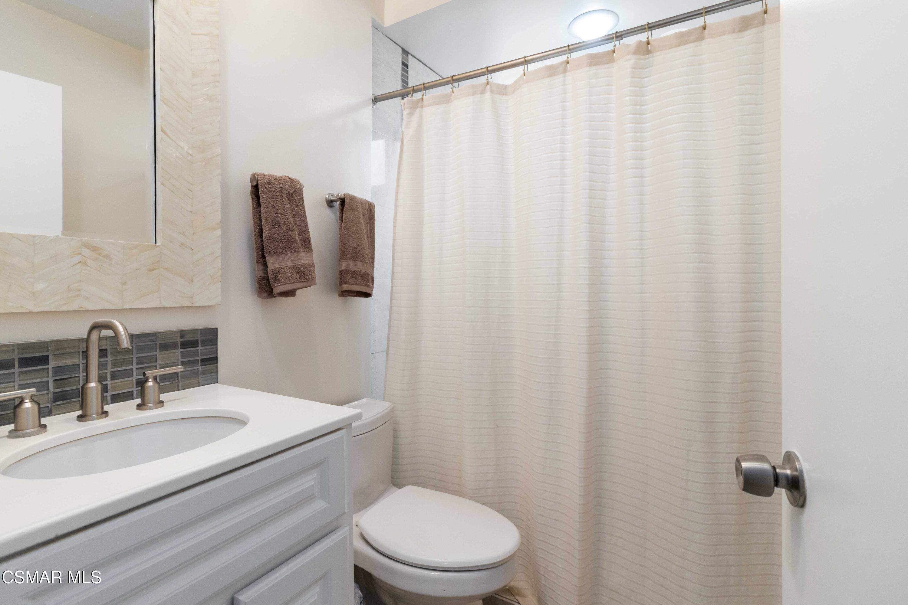 705 Wishard Avenue Simi Valley, CA 93065 - Photo 33 of 50 a bathroom with a sink a toilet and shower curtain