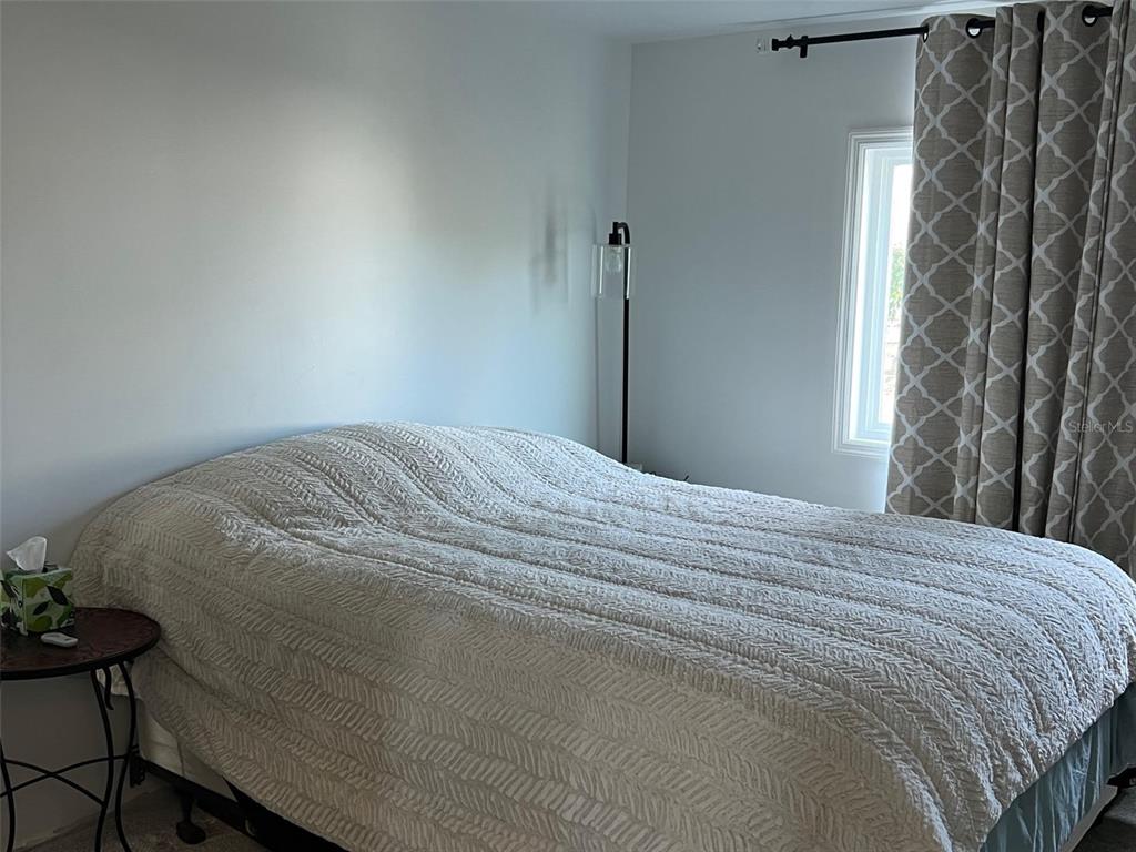 576 Queen Palm Largo, FL 33778 - Photo 24 of 33 a large bed sitting in a bedroom next to a window and a chair