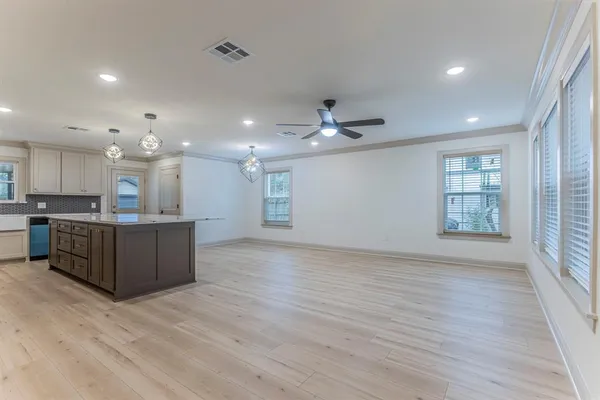 a kitchen with stainless steel appliances granite countertop a stove a sink dishwasher and a refrigerator with wooden floor