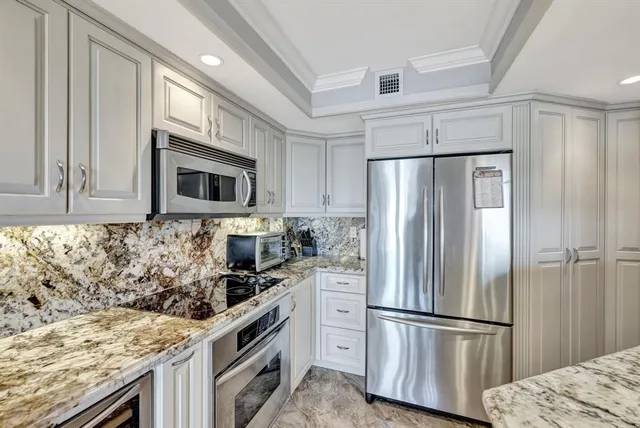 a kitchen with stainless steel appliances granite countertop a refrigerator stove and microwave
