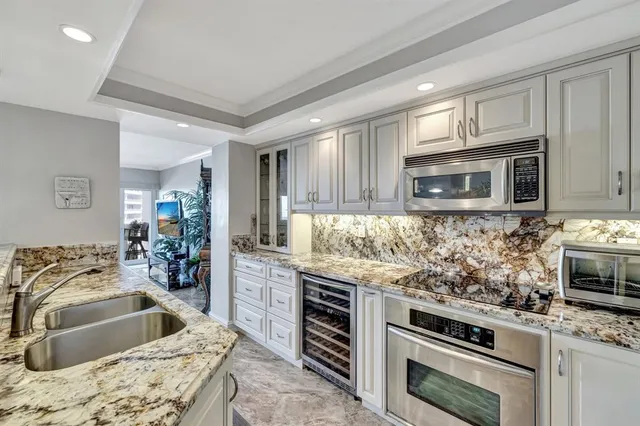 a kitchen with granite countertop a sink stove and microwave