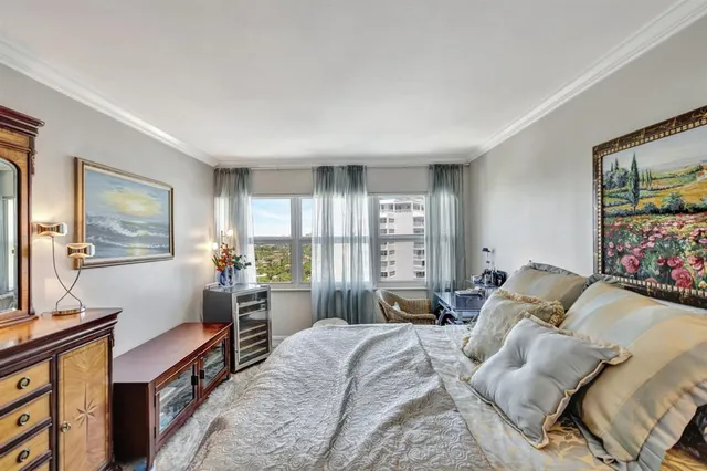 a bedroom with a bed and a dresser next to a window