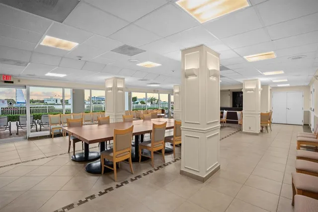 a dining area with stainless steel appliances lots of white furniture a dining table and chairs