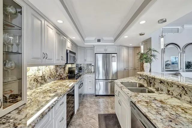 a kitchen with granite countertop a sink stove and refrigerator