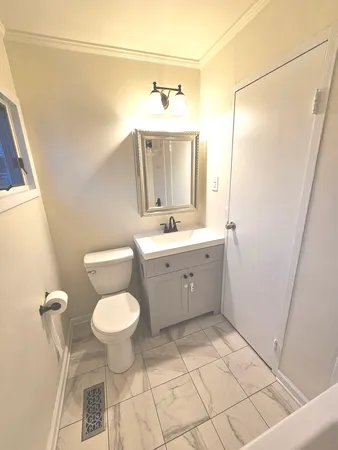 a bathroom with a sink toilet mirror and vanity