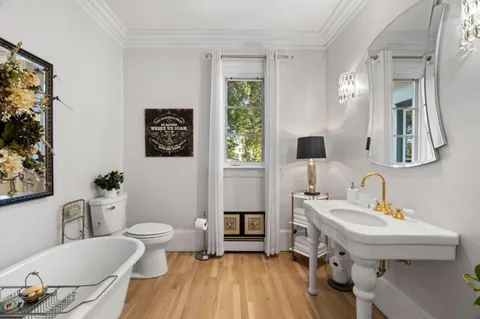 a bedroom with a bed and a chair with the bookshelf