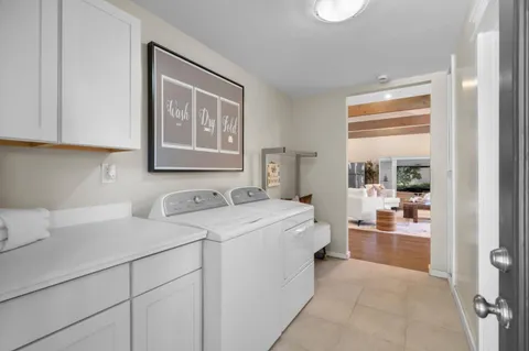 a front view of a house with a yard and potted plants