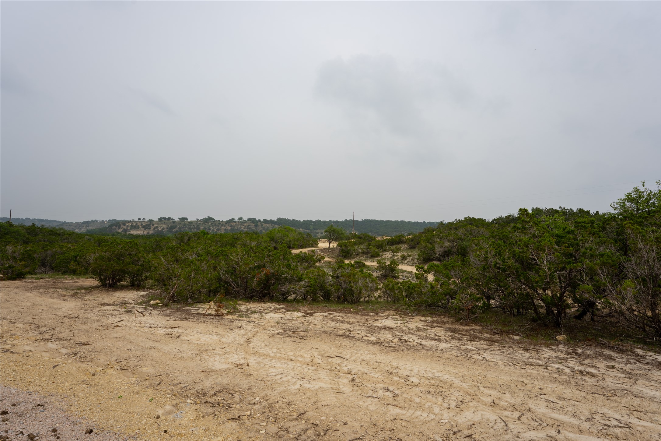 Lot 3 Ranch Road 165 Dripping Springs, TX 78620 - Photo 10 of 11 Expansive undeveloped land featuring natural terrain and mature shrubbery under an open sky
