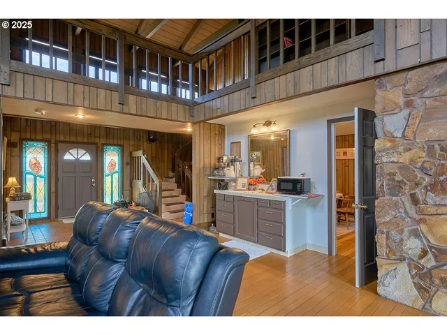 a living room with furniture a flat screen tv and kitchen view