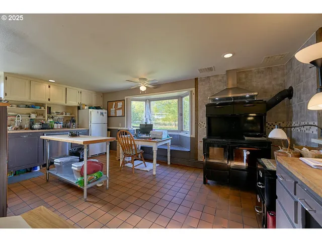 a living room with furniture a flat screen tv and kitchen view