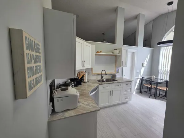 a kitchen with stainless steel appliances a sink a stove a refrigerator and wooden floor