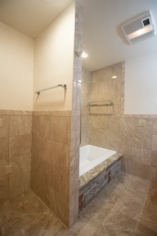a bathroom with a tub a sink and a shower