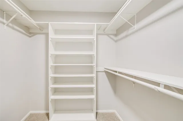 a view of walk in closet with empty racks