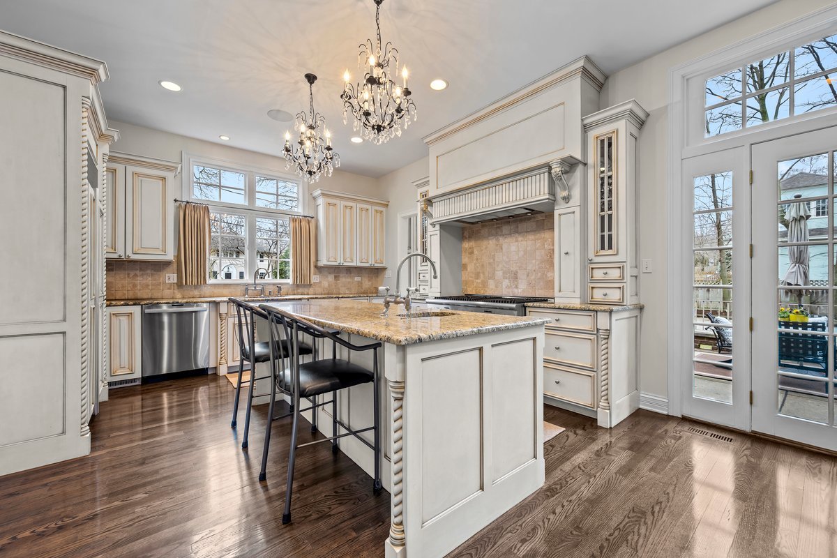 410 Cedar Street Winnetka, IL 60093 - Photo 16 of 57 a kitchen with stainless steel appliances granite countertop a kitchen island a stove a table and chairs in it