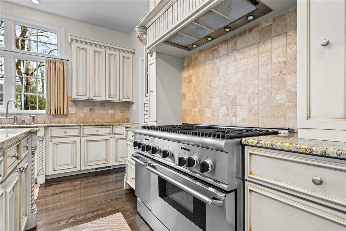 410 Cedar Street Winnetka, IL 60093 - Photo 19 of 57 a kitchen with granite countertop a stove sink and cabinets