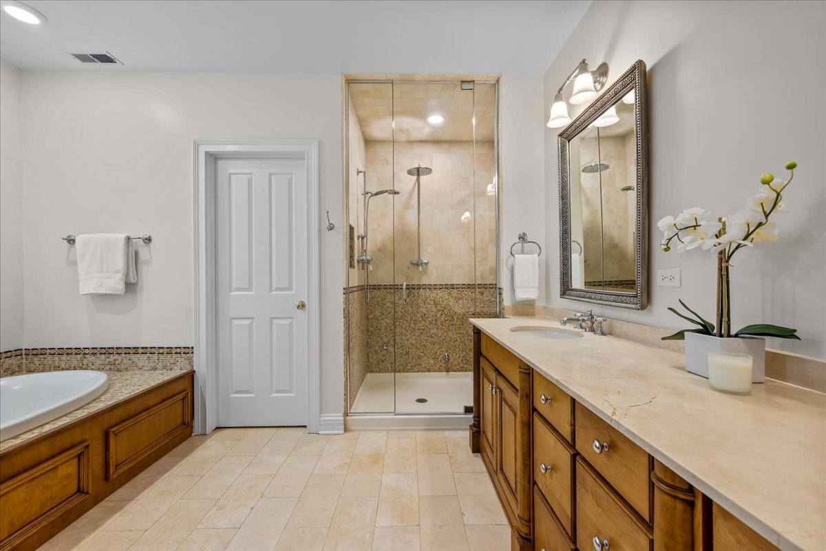 410 Cedar Street Winnetka, IL 60093 - Photo 30 of 57 a spacious bathroom with a double vanity sink a mirror and a shower