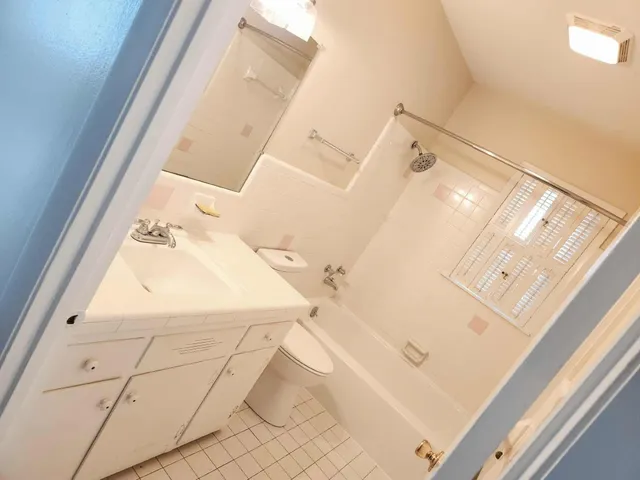 a bathroom with a sink and mirror with bathtub