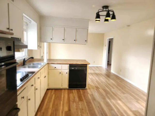 a kitchen with a sink a stove and cabinets