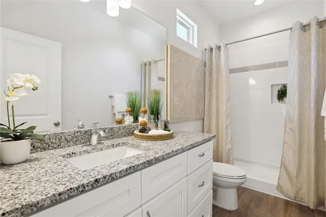 a bathroom with a granite countertop sink toilet and shower