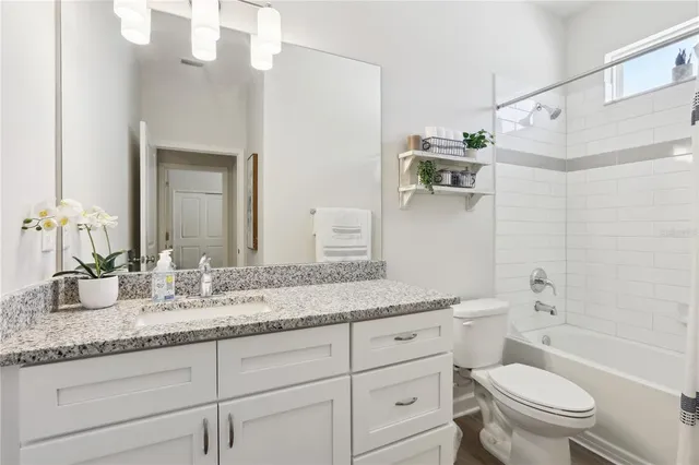 a bathroom with a granite countertop toilet sink and mirror
