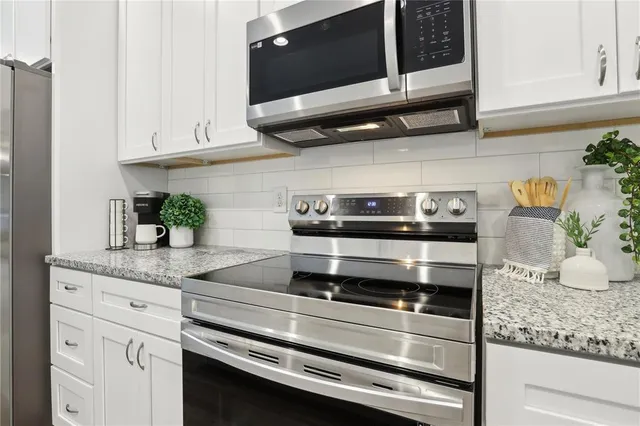 a kitchen with granite countertop cabinets and steel stainless steel appliances