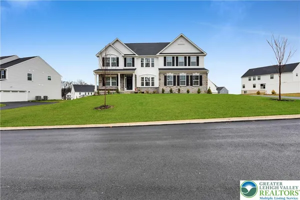 a view of a big house with a big yard and large trees
