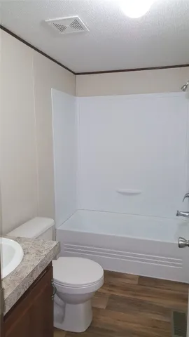 a bathroom with a granite countertop sink and a toilet