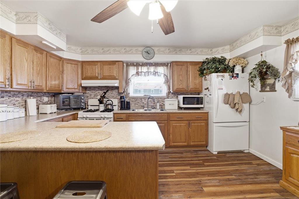 908 15th Street Elizabeth, PA 15037 - Photo 11 of 47 a kitchen with a refrigerator a stove a sink and dishwasher with wooden floor