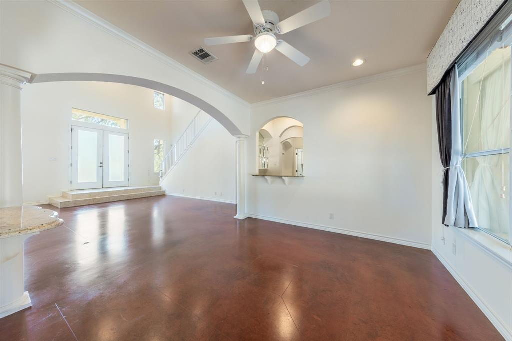 1704 Randolph Ridge Trail Austin, TX 78746 - Photo 12 of 23 Unfurnished living room featuring, arched walkways, ceiling fan, and crown molding