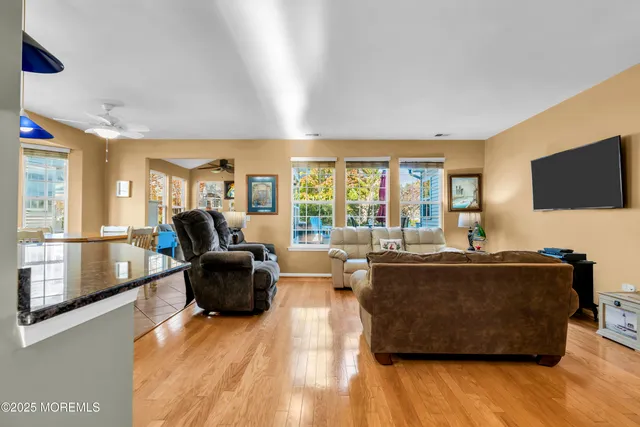 a kitchen with stainless steel appliances kitchen island granite countertop a stove a refrigerator a oven a sink with a dining table and chairs