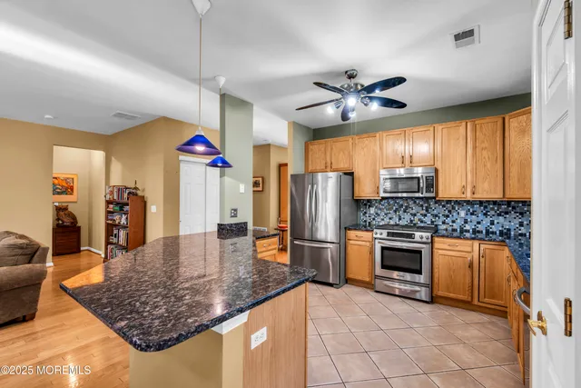 a large kitchen with stainless steel appliances kitchen island granite countertop a sink and cabinets