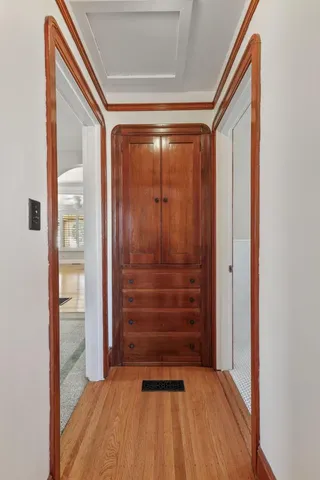 a view of a hallway with wooden floor and closet