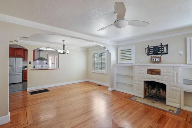 a view of a livingroom with wooden floor and a fireplace