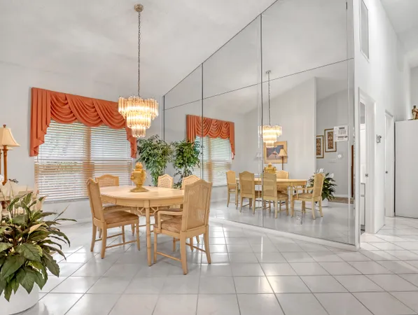 a very nice looking dining room with kitchen island furniture a chandelier and a chandelier