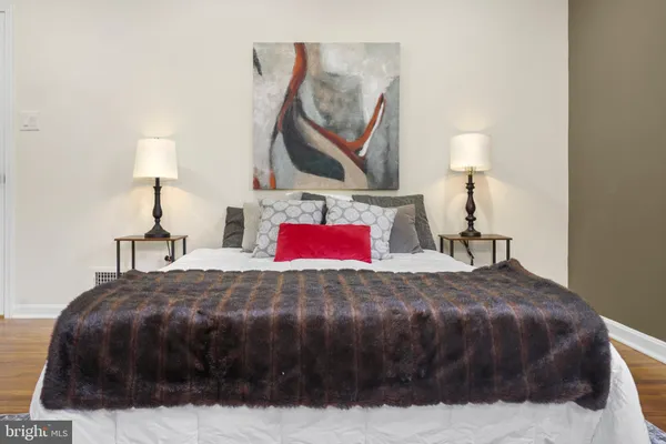 a bedroom with a bed and a painting on the wall