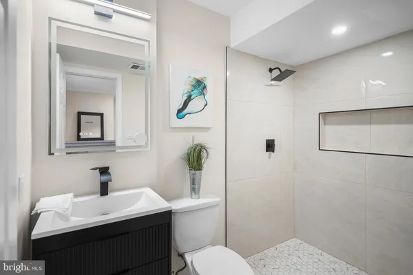 a bathroom with a sink a toilet and mirror