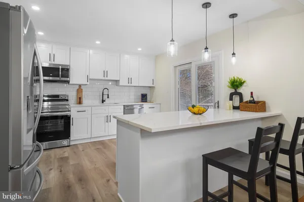 a kitchen with a sink a counter top space appliances and cabinets