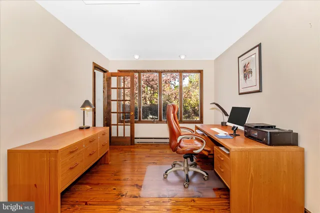 a view of a workspace with furniture and a window