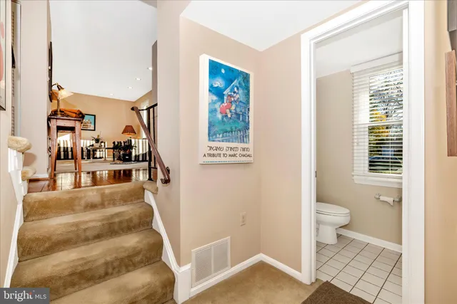 a view of a hallway with a livingroom and a bathroom with bathtub