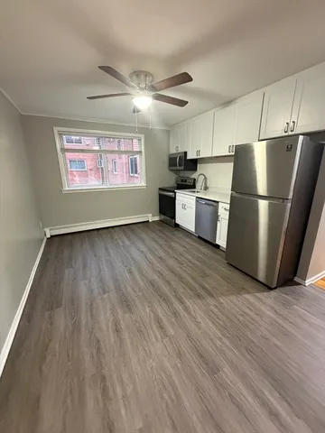 a view of kitchen with stainless steel appliances wooden floor and electronic appliances