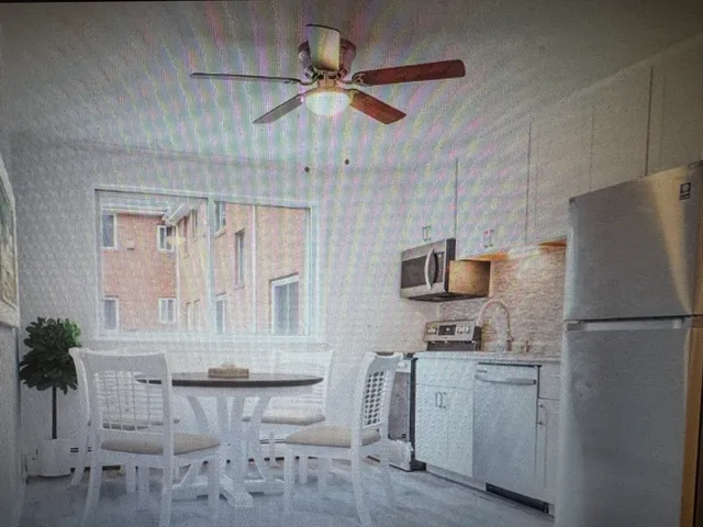 a kitchen with white cabinets and refrigerator