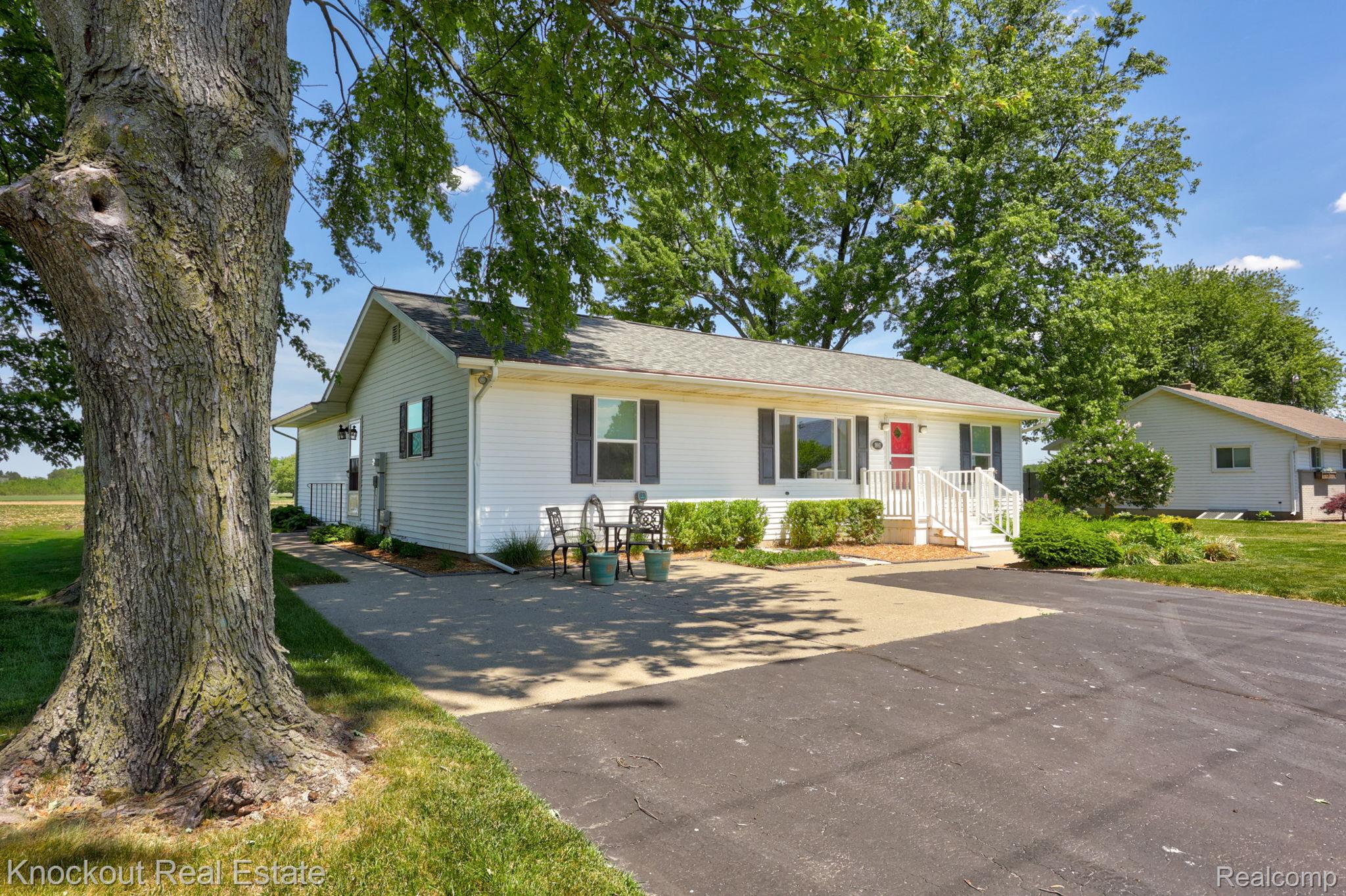 9941 Lange Road Birch Run, MI 48415 - Photo 2 of 42 Ranch-style residence featuring white siding, dark shutters, and a red entry door