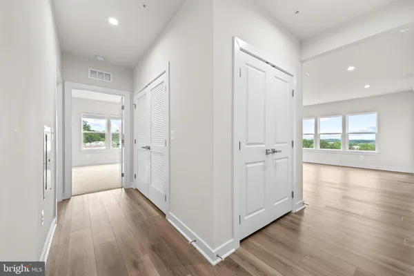 a view of a hallway with wooden floor and windows