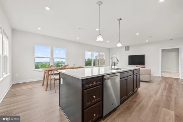 a large kitchen with kitchen island a sink a counter space and stainless steel appliances