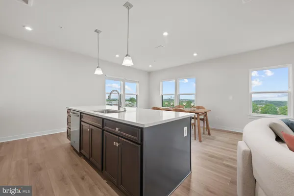 a kitchen with stainless steel appliances granite countertop a sink a window and wooden floor