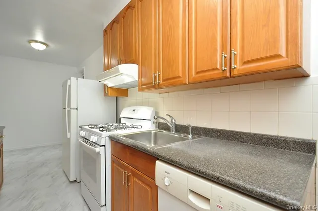 a kitchen with stainless steel appliances granite countertop a sink a stove and a microwave