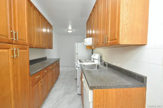 a kitchen with granite countertop stainless steel appliances a sink and a window
