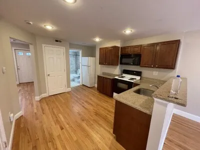 a kitchen with granite countertop a refrigerator stove and sink