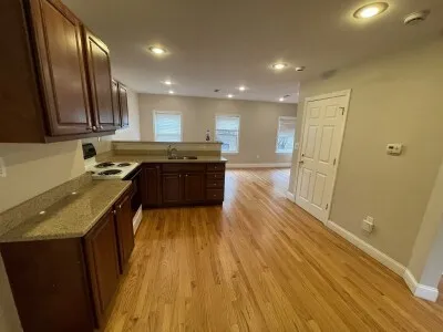 a large kitchen with wooden floor and a sink
